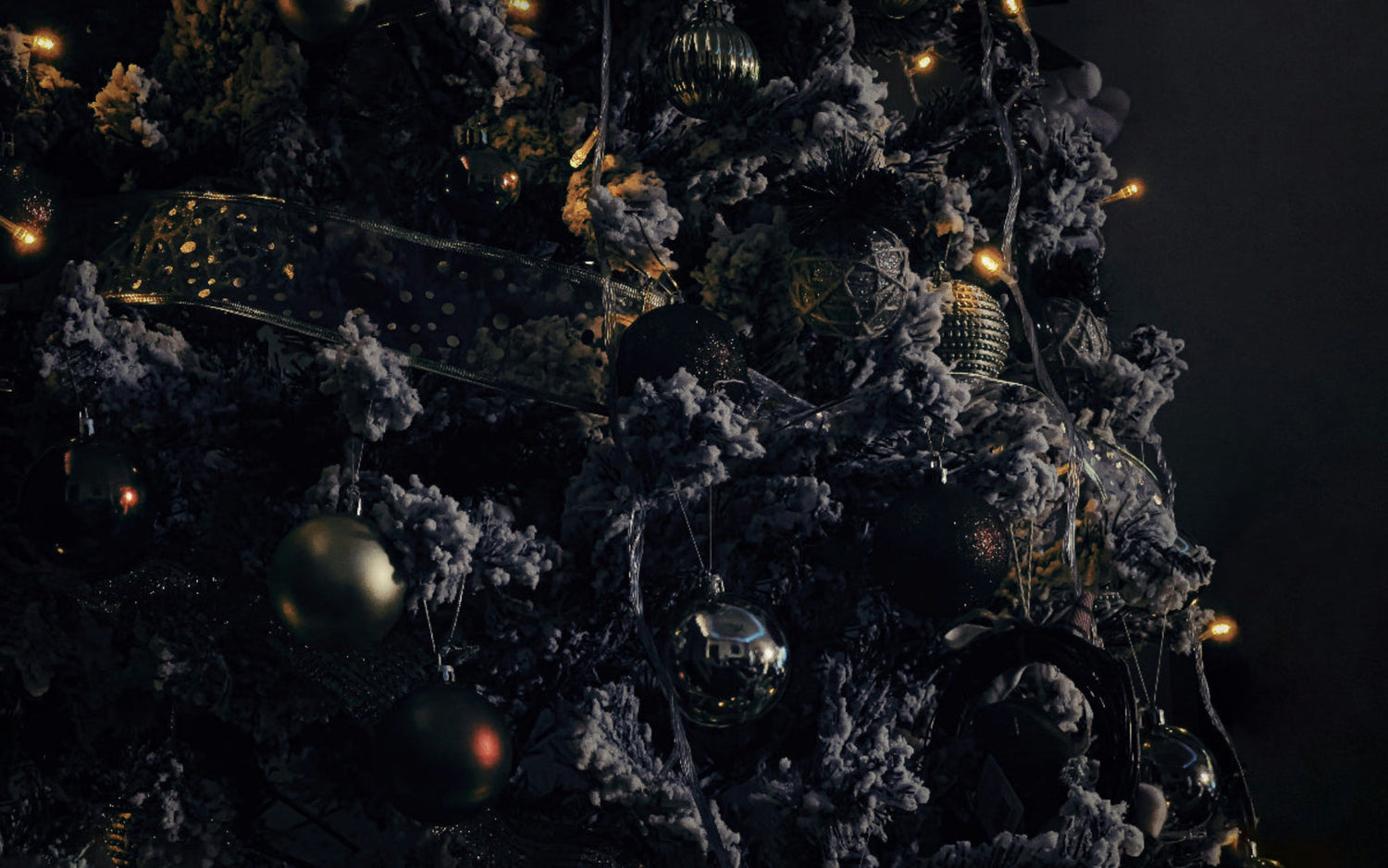 Decorative Christmas tree with ornaments and lights against a dark background